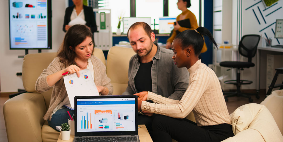 Two women and a man sitting on a couch discussing data