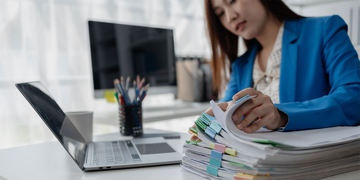 A working woman sitting at a table checking her files