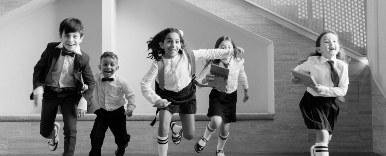 A group of kids in school uniforms running down the stairs